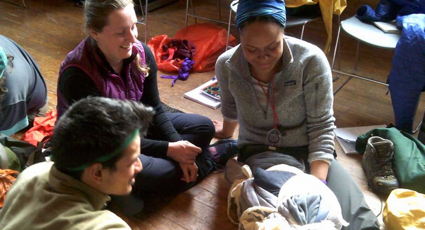 Two people tend to another during a wilderness first aid exercise. 